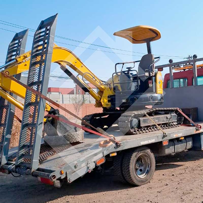Miniexcavadora sobre camión con amarras.