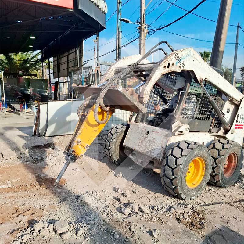 Miniexcavadora sobre camión con amarras.