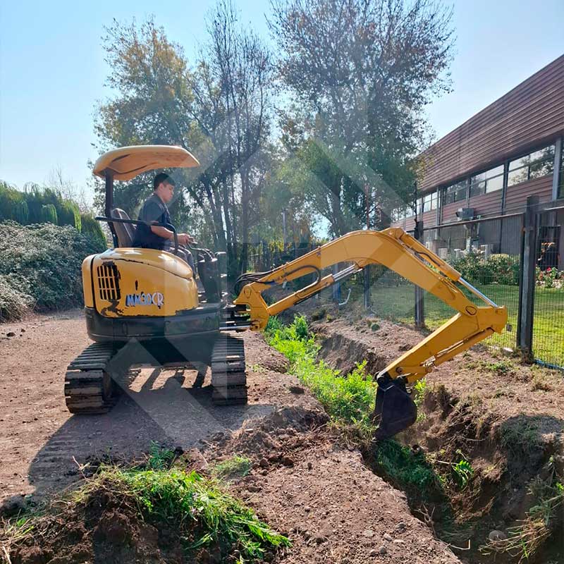 Miniexcavadora sobre camión con amarras.